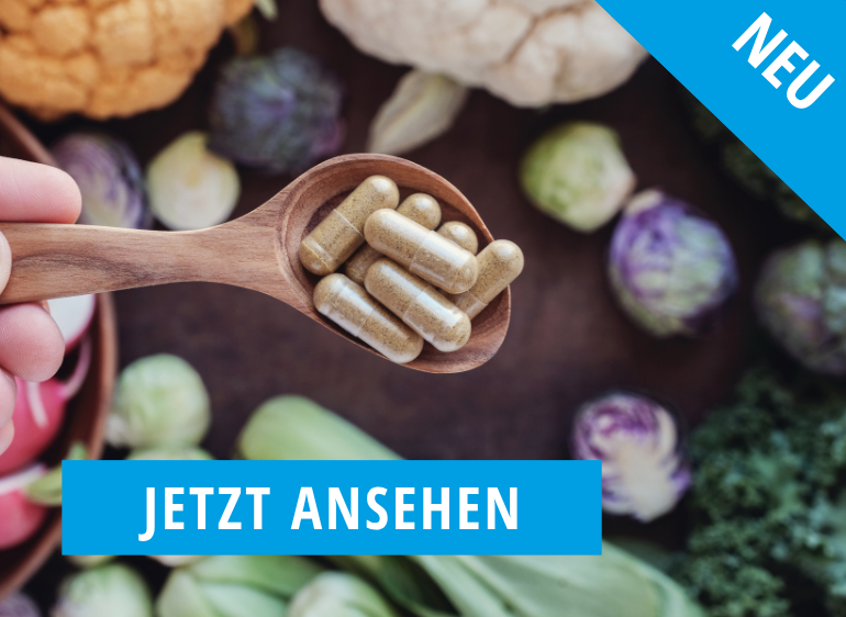 Kapseln im Holzlöffel mit frischem Gemüse im Hintergrund, gekennzeichnet als „Neu“ – gesunde Nahrungsergänzung entdecken